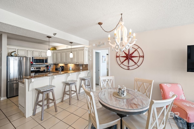 dining area featuring light tile patterned floors, a textured ceiling, and an inviting chandelier