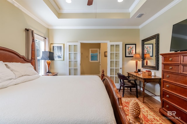 10752 Westwood Ave, Fairhope, AL 36532 - bedroom with a tray ceiling, wood finished floors, french doors, ornamental molding, and recessed lighting