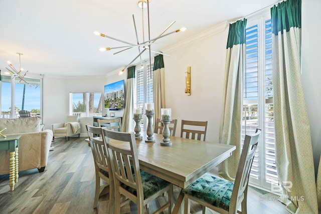 dining room with crown molding, an inviting chandelier, and wood-type flooring