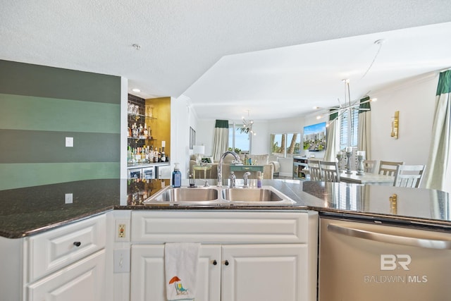 kitchen featuring dishwasher, sink, an inviting chandelier, and white cabinets