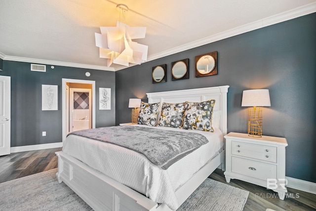 bedroom featuring ornamental molding, hardwood / wood-style flooring, and connected bathroom