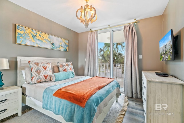 bedroom featuring hardwood / wood-style flooring, access to outside, and a notable chandelier