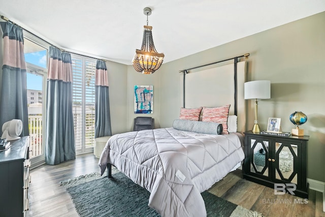 bedroom with an inviting chandelier, hardwood / wood-style flooring, and access to outside