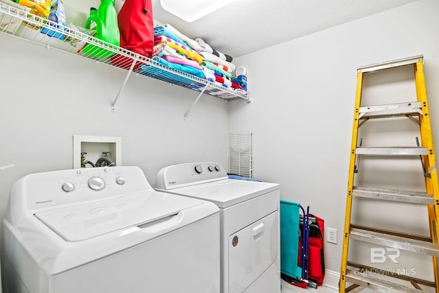 clothes washing area with washing machine and dryer