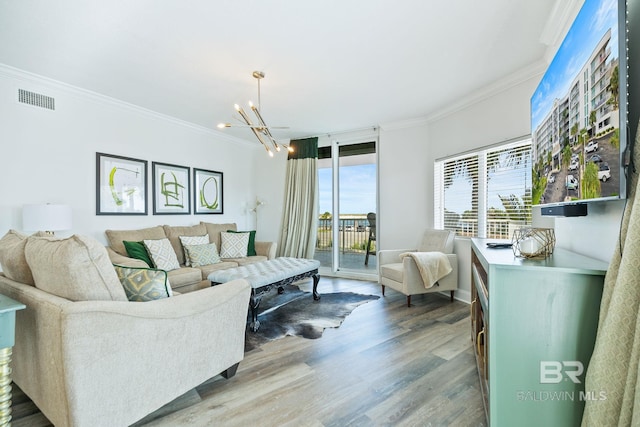 living room with crown molding, a notable chandelier, and light hardwood / wood-style flooring