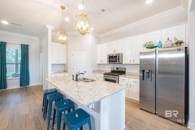 kitchen with a center island with sink, appliances with stainless steel finishes, sink, and light hardwood / wood-style flooring