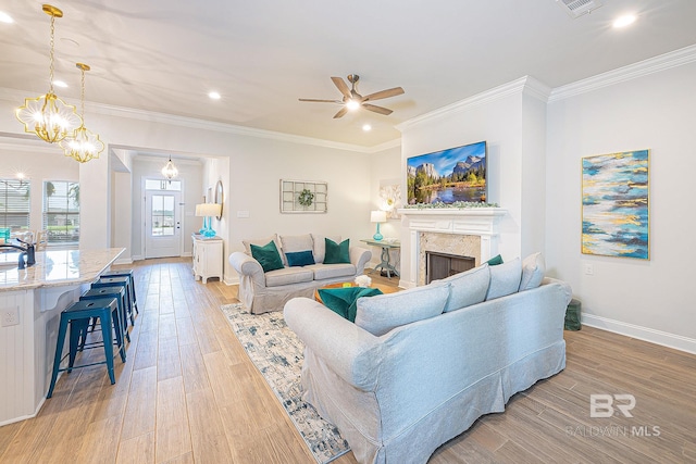 living room featuring a premium fireplace, wood-type flooring, and crown molding