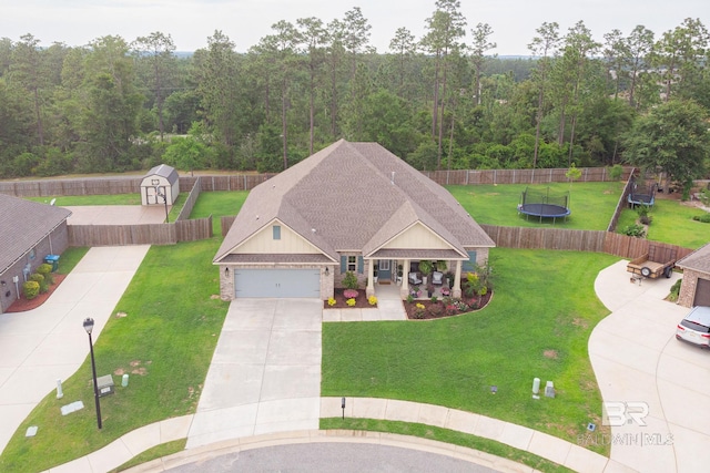 view of front of home featuring a garage, a trampoline, and a front lawn