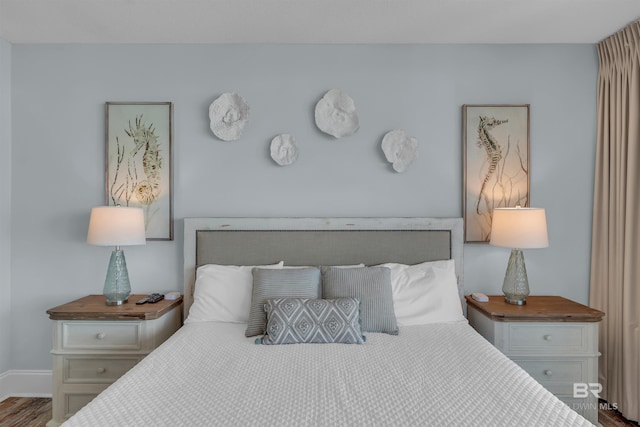 bedroom featuring baseboards and wood finished floors