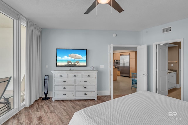 bedroom with stainless steel built in fridge, visible vents, light wood-style flooring, baseboards, and ceiling fan