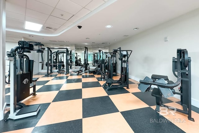 exercise room featuring tile patterned floors, visible vents, and a paneled ceiling