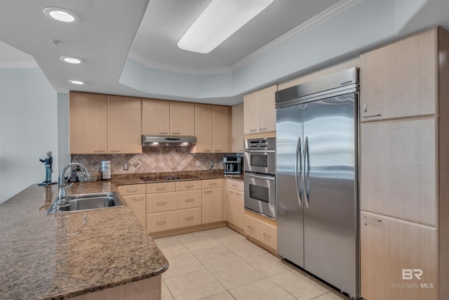 kitchen featuring a sink, light brown cabinetry, ornamental molding, stainless steel appliances, and under cabinet range hood