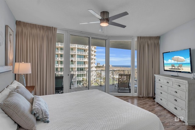 bedroom with wood finished floors, a ceiling fan, access to exterior, and floor to ceiling windows