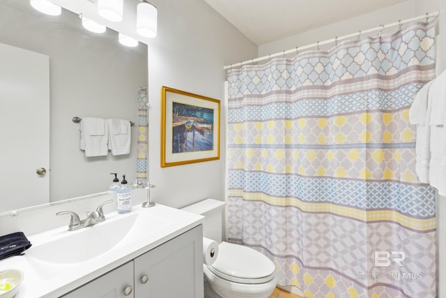 full bath with curtained shower, a textured ceiling, toilet, and vanity