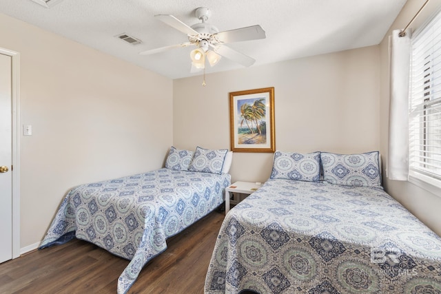 bedroom featuring visible vents, multiple windows, and wood finished floors