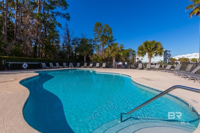 community pool featuring a patio area and fence