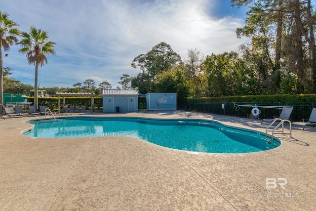 pool with a patio, a pergola, and fence