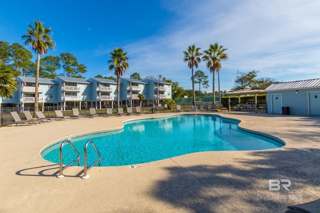 community pool featuring a patio and fence