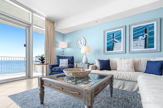 living area with light tile patterned floors, a wall of windows, and a water view