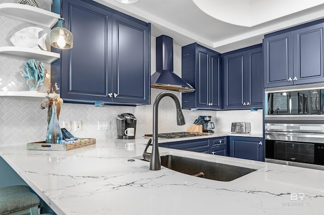 kitchen featuring open shelves, wall chimney range hood, blue cabinetry, and stainless steel appliances