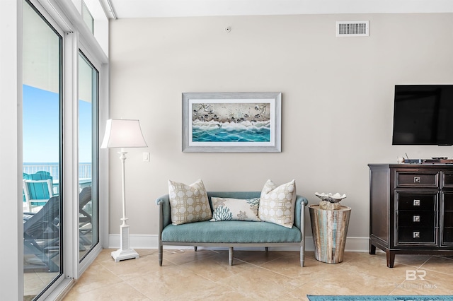 living area featuring a wealth of natural light, visible vents, and light tile patterned flooring