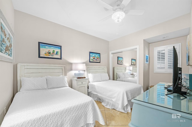 bedroom with light tile patterned floors, a closet, and a ceiling fan