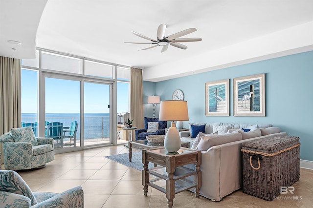 living room featuring a water view, light tile patterned floors, expansive windows, and a ceiling fan