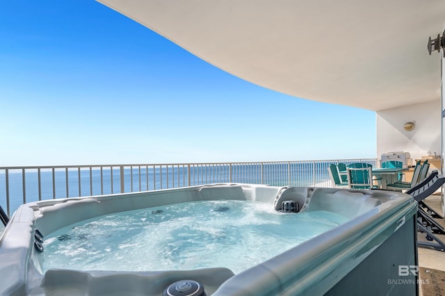 exterior space featuring a water view and a hot tub