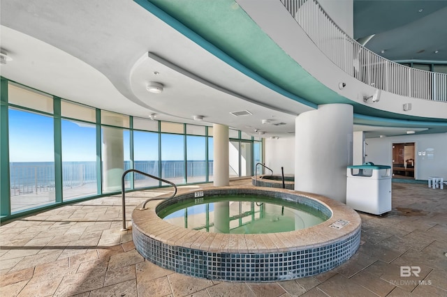 view of pool featuring an indoor hot tub and a water view