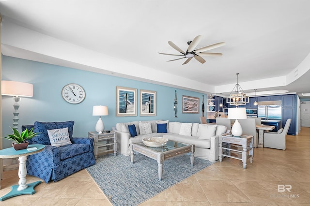 living room featuring ceiling fan with notable chandelier and light tile patterned floors