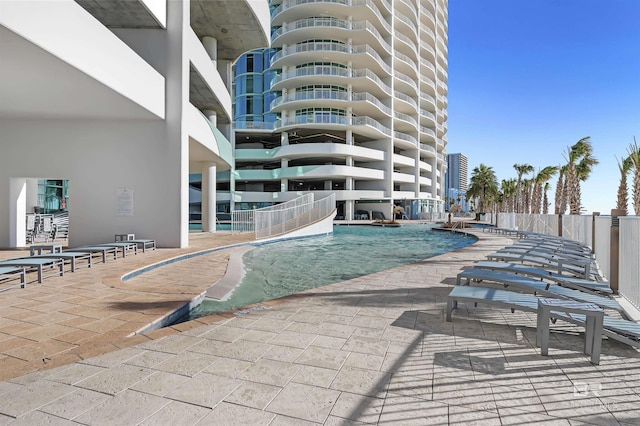 view of swimming pool featuring a patio area and fence