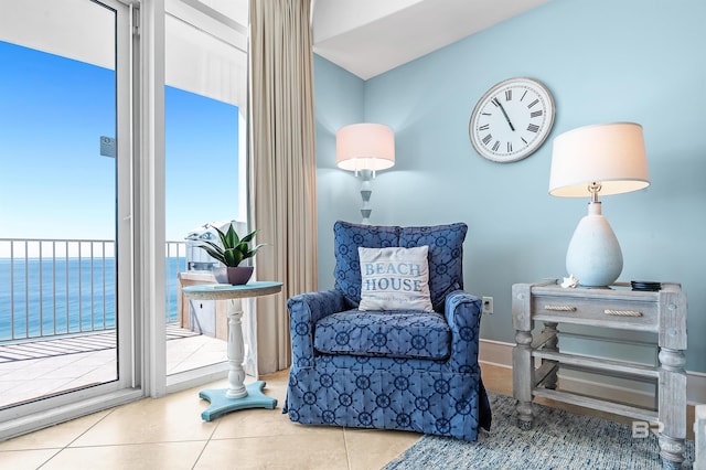 sitting room featuring a water view and tile patterned floors