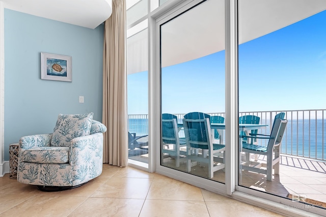 living area featuring a water view and light tile patterned floors