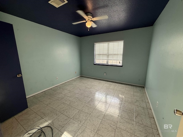 spare room featuring ceiling fan, a textured ceiling, visible vents, and baseboards