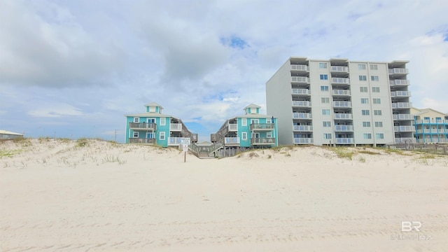 view of building exterior featuring a water view and a beach view