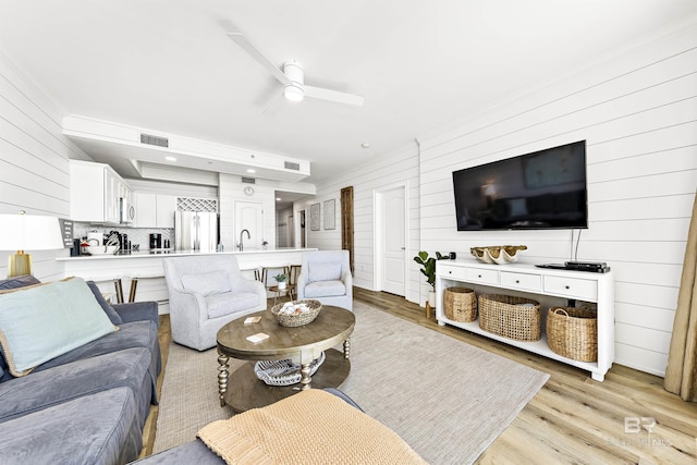 453 Dune Dr Unit 404, Gulf Shores, AL 36542 - living area featuring wooden walls, ceiling fan, and light wood finished floors