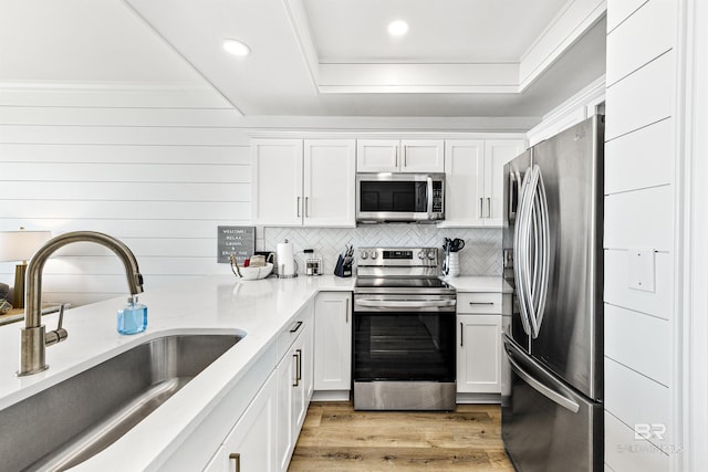 453 Dune Dr Unit 404, Gulf Shores, AL 36542 - kitchen featuring stainless steel appliances, white cabinetry, recessed lighting, a raised ceiling, and decorative backsplash