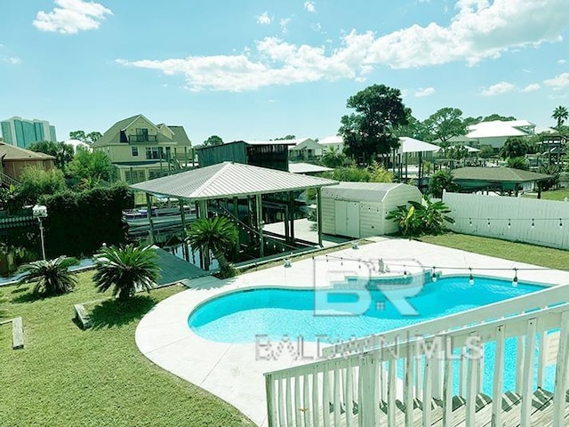 view of pool featuring a patio and a yard