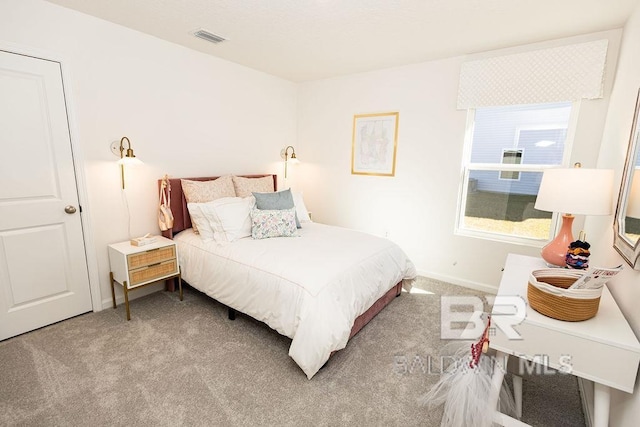 carpeted bedroom with visible vents and baseboards