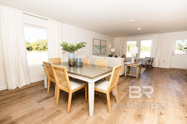 dining space with light wood finished floors and baseboards