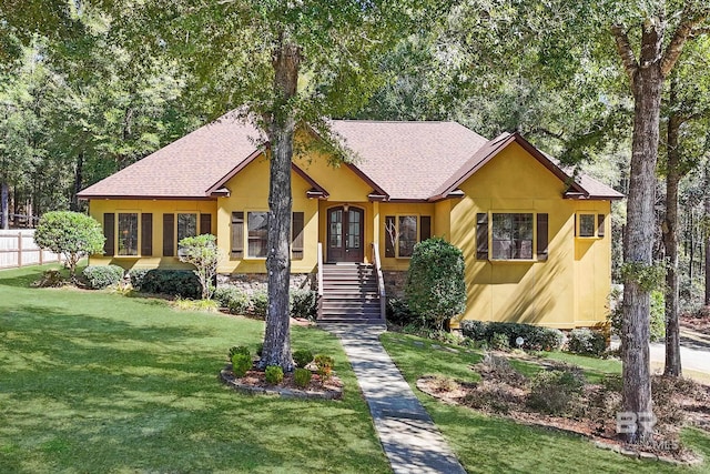 single story home with french doors, roof with shingles, stucco siding, a front yard, and fence