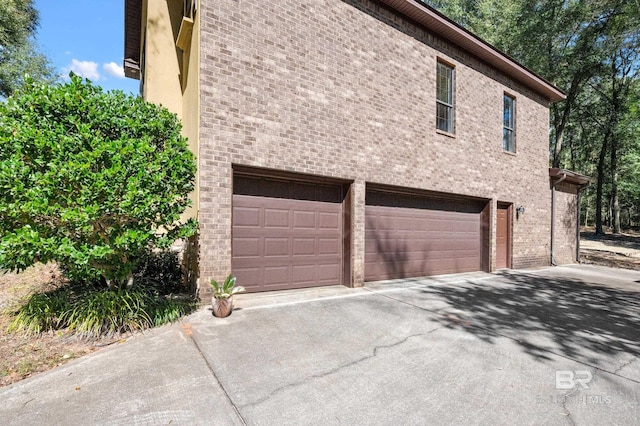 view of home's exterior featuring brick siding, driveway, and an attached garage