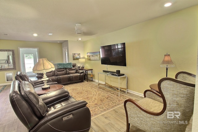 living room featuring wood-type flooring and ceiling fan