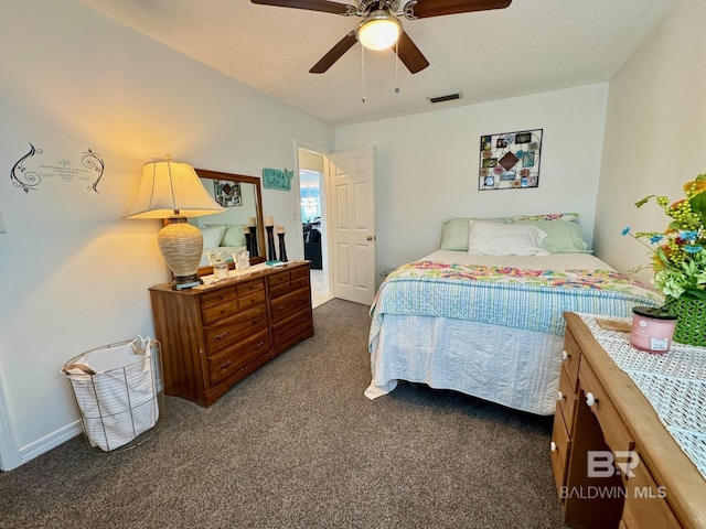 bedroom with dark colored carpet, visible vents, a textured ceiling, and ceiling fan