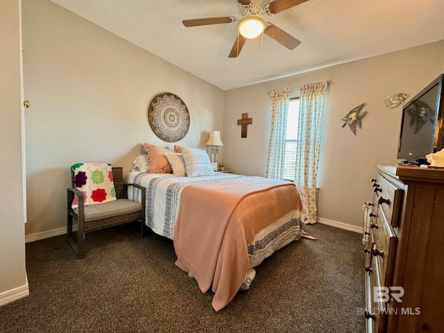 bedroom featuring ceiling fan, a textured ceiling, baseboards, and dark colored carpet