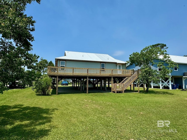 back of house featuring a carport, stairway, a lawn, and a wooden deck