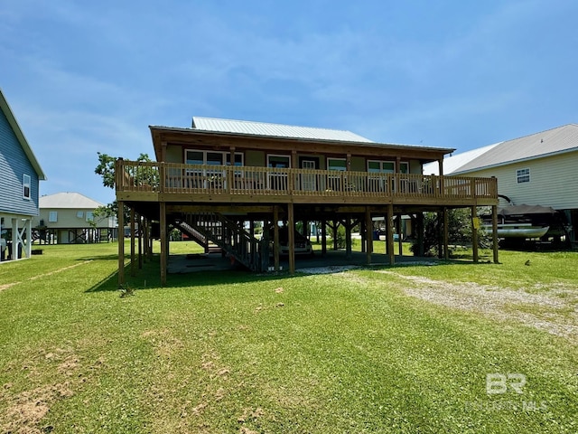 rear view of property featuring a deck, a carport, and a lawn