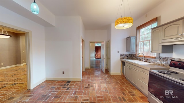 kitchen featuring decorative backsplash, white electric range, sink, and hanging light fixtures