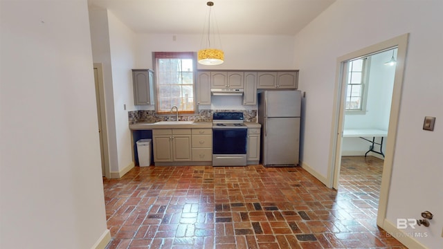 kitchen with stainless steel refrigerator, sink, white electric stove, pendant lighting, and gray cabinets