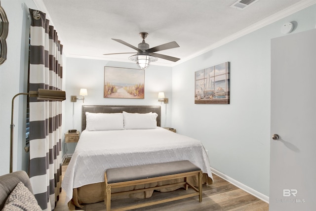 388 E Beach Blvd Unit A-2, Gulf Shores, AL 36542 - bedroom with crown molding, ceiling fan, baseboards, wood finished floors, and visible vents